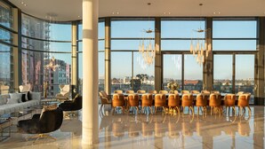 A spacious, modern hotel lobby with large windows offering city views, a seating area with sofas and chairs, and a dining setup with tables and chairs. - ⚜ EVEN ISRAEL PENTHOUSE ⚜JACUZZI⚜5 royal Masters⚜ (jerusalem)