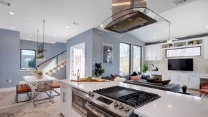 Una cucina moderna con isola centrale, forno integrato ed elettrodomestici in acciaio inossidabile.
