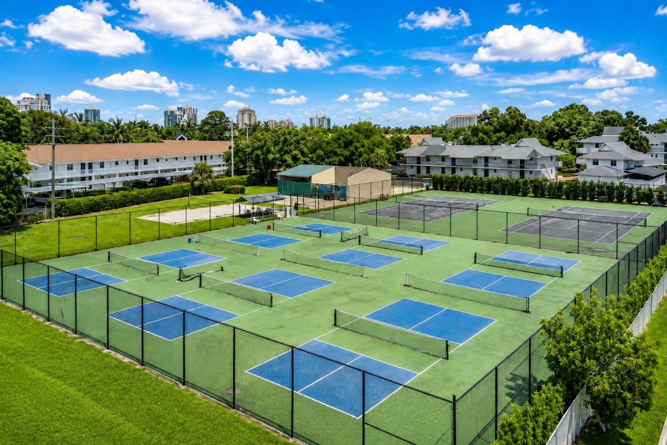 Tenniskenttäalue, jossa on useita kenttiä, ja jonka ympärillä on viheralueita ja asuinrakennuksia.
