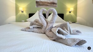 Habitación de hotel con una cama, dos lámparas fijadas a la pared y un cuadro en la pared.