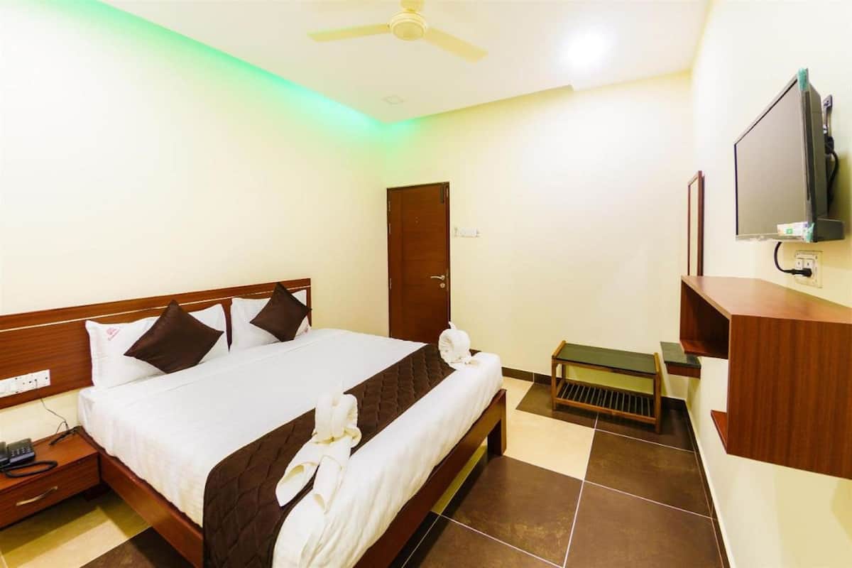 A hotel room with a bed, a television, a desk, and a wardrobe.