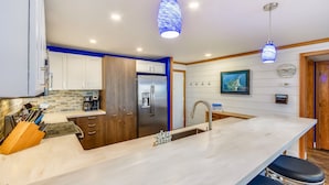 A modern kitchen with a marble countertop, stainless steel appliances, and pendant lighting. - 601C is a Gorgeous 2 BR with Boat Slip (Destin)