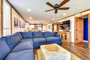 A modern living room with a sectional sofa, a wooden coffee table, and a ceiling fan. - 601C is a Gorgeous 2 BR with Boat Slip (Destin)
