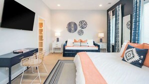 Una habitación de hotel moderna con una cama grande, un escritorio y un televisor.