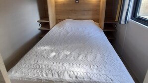 A bedroom with a wooden headboard, two bedside tables, a patterned bedspread, and a window with curtains. - House with garden 2 bedrooms Soulac Sur Mer 500m from the beach (Soulac-sur-Mer)