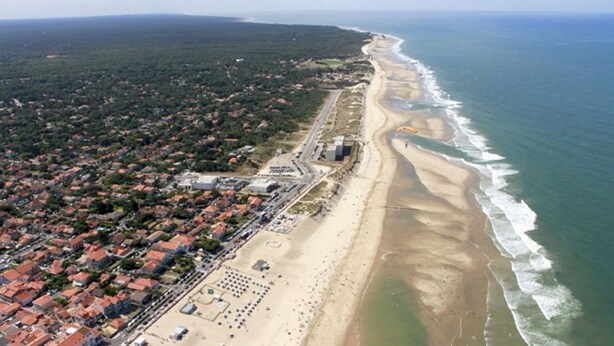 An aerial view of a coastal area with a beach, residential buildings, and a road running parallel to the shore. - House with garden 2 bedrooms Soulac Sur Mer 500m from the beach (Soulac-sur-Mer)