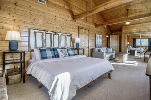 Cozy bedroom with a large bed, two nightstands, and a framed artwork above.