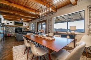 A spacious living area with a wooden ceiling, stone fireplace, and a large window offering a view of the outdoors. - Irish Goodbye Over Looking Center Hill Lake (Baxter)