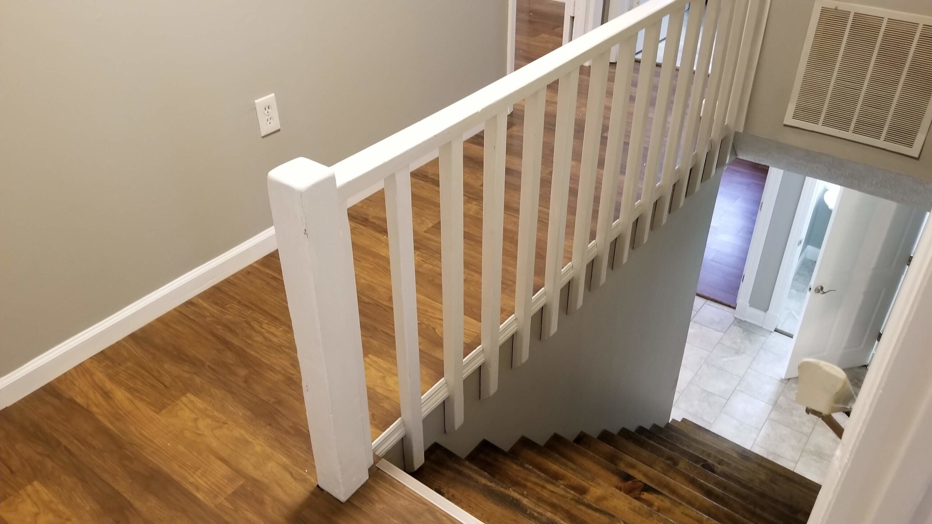 A staircase with white railings and wooden steps.