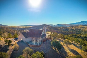 A single-story house with a sloped roof, a chimney, and a fenced yard. - Royal Ranch (Cañon City)