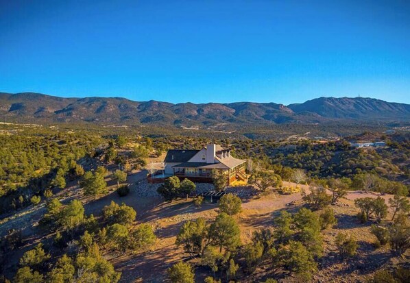 A house surrounded by trees and mountains.