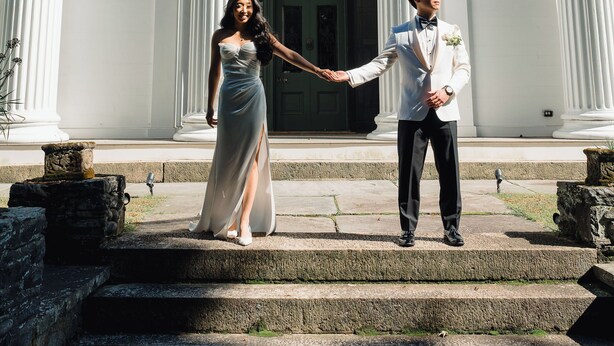 A couple holding hands in front of a building with large columns and a grand entrance. - Beautiful historic home in Newport (Middletown)