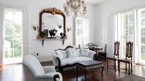 A spacious room with a large mirror, elegant furniture, and a chandelier. - Beautiful historic home in Newport (Middletown)