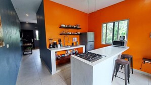Una cocina moderna con una isla central, un refrigerador y un microondas.
