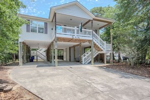 A two-story house with a covered porch and a staircase leading to the upper level.