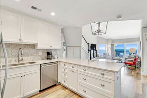 Enjoy meals in the kitchen with a view of the ocean, leading to a dining area with a beautiful view.