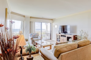 Relax in this stylish living room with a sofa, coffee table, and flat-screen TV, offering a peaceful atmosphere.