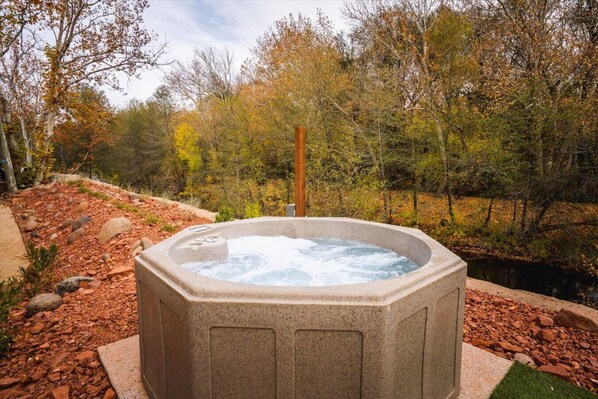 A hot tub in a natural setting with a wooden post nearby. - 19 Creekside Retreat | Upper + Closest to Creek (Sedona)