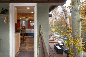 A wooden interior with a kitchen area, a dining space, and a view of a tree-lined outdoor deck. - 19 Creekside Retreat | Upper + Closest to Creek (Sedona)