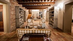 A cozy room with exposed wooden beams, a checkered sofa, and a staircase leading to a balcony. - Villa il Sogno - Homelike Villas (Ostra Vetere)