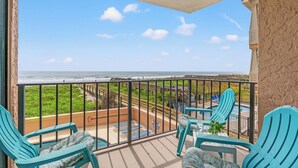 A balcony with a view of the ocean, equipped with chairs and a small table. - Carolina Reef 101 - 2 Bedroom Ocean Front Condo (North Myrtle Beach)