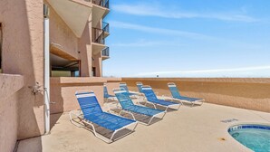 Un área junto a la piscina con sillones de descanso y una piscina.