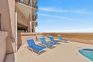 Un espace aménagé au bord de la piscine, avec des chaises longues et une piscine.