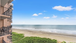 Un hotel frente a la playa con balcón con vistas al océano.