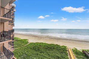 Un hôtel situé en bord de mer, avec un balcon donnant sur l’océan.