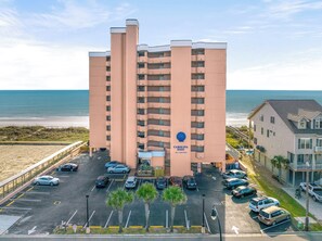 Un hôtel à plusieurs étages avec vue sur la plage, un parking et une enseigne indiquant « Carolina Reef ».