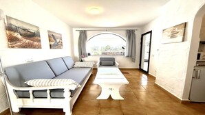 A modern living room with a sofa, a coffee table, and a view through a large window. - Welooveyou Scorpius Starlight B34 (Costa Calma (incl. Urbanización Cañada del Río))