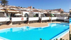 Une piscine à l’eau d’un bleu cristallin, entourée de murs blancs et de marches en pierre.
