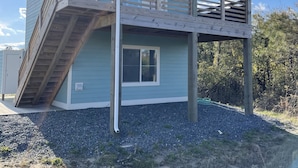 A two-story house with a balcony, a staircase, and a large window. - Romantic Little Getaway in 4X4 beach (Corolla)