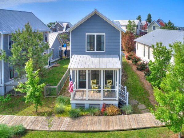 A two-story house with a covered porch and a small deck.