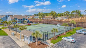 A residential area with houses, a tennis court, and a parking lot. - Golf Colony at Deerfield 33-I (Myrtle Beach)