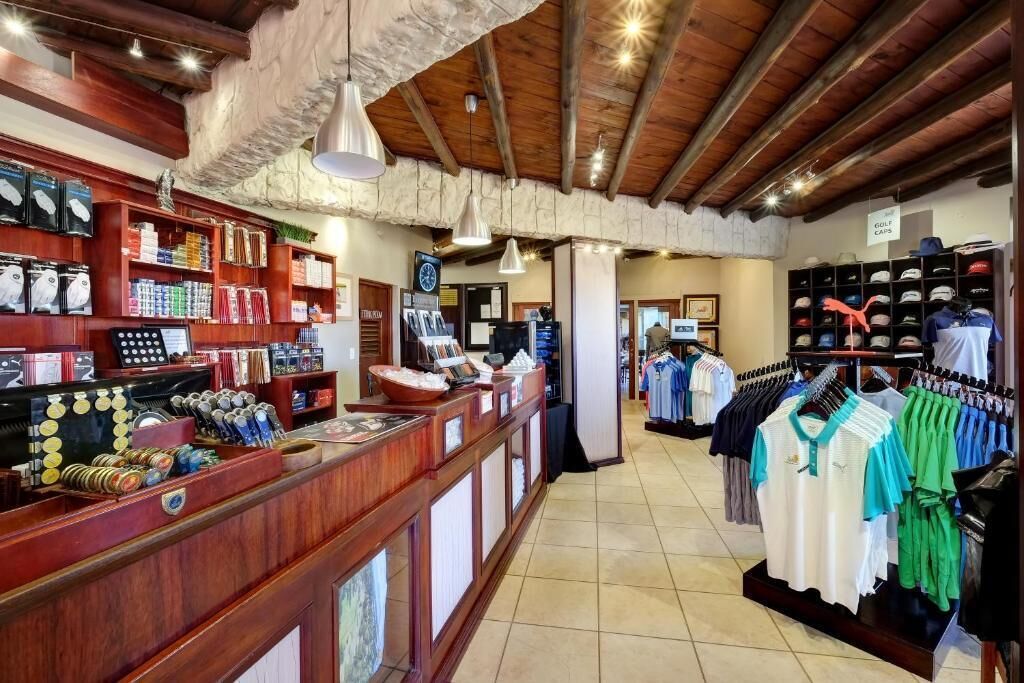 Een winkel met houten planken waarop golfuitrusting en kleding tentoongesteld zijn.