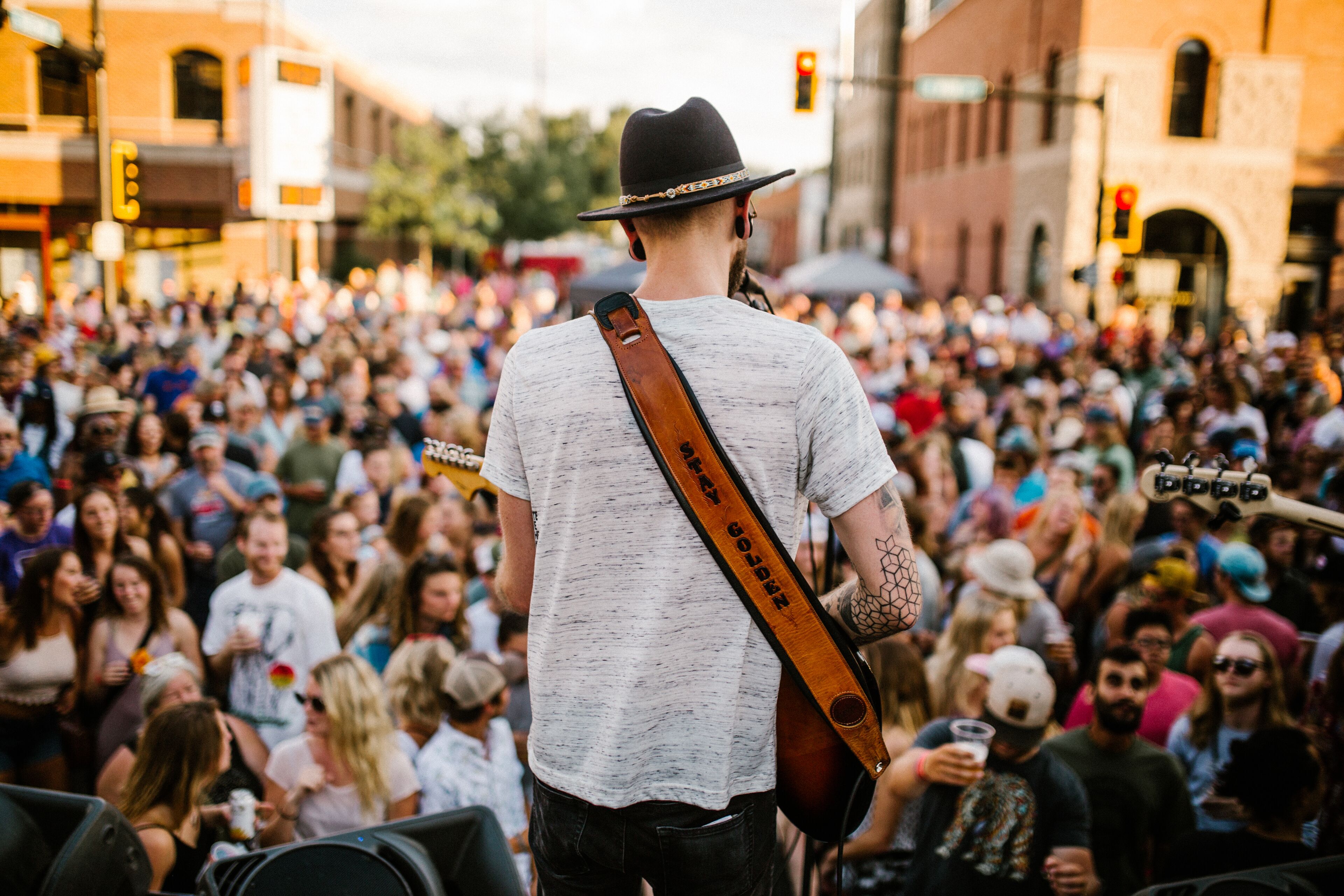 A crowded outdoor event with a person holding a guitar.