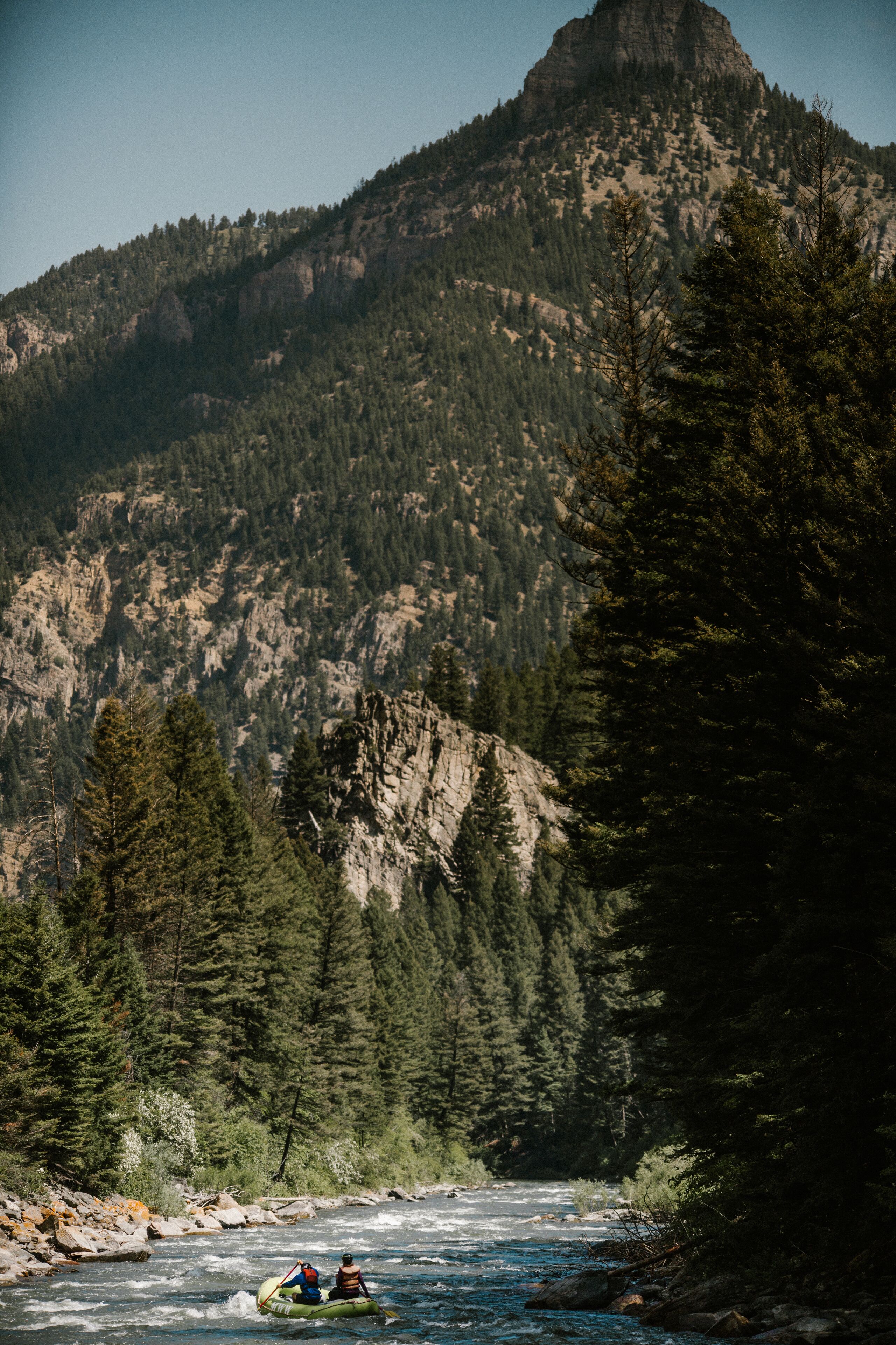 Une rivière avec une montagne rocheuse en arrière-plan.