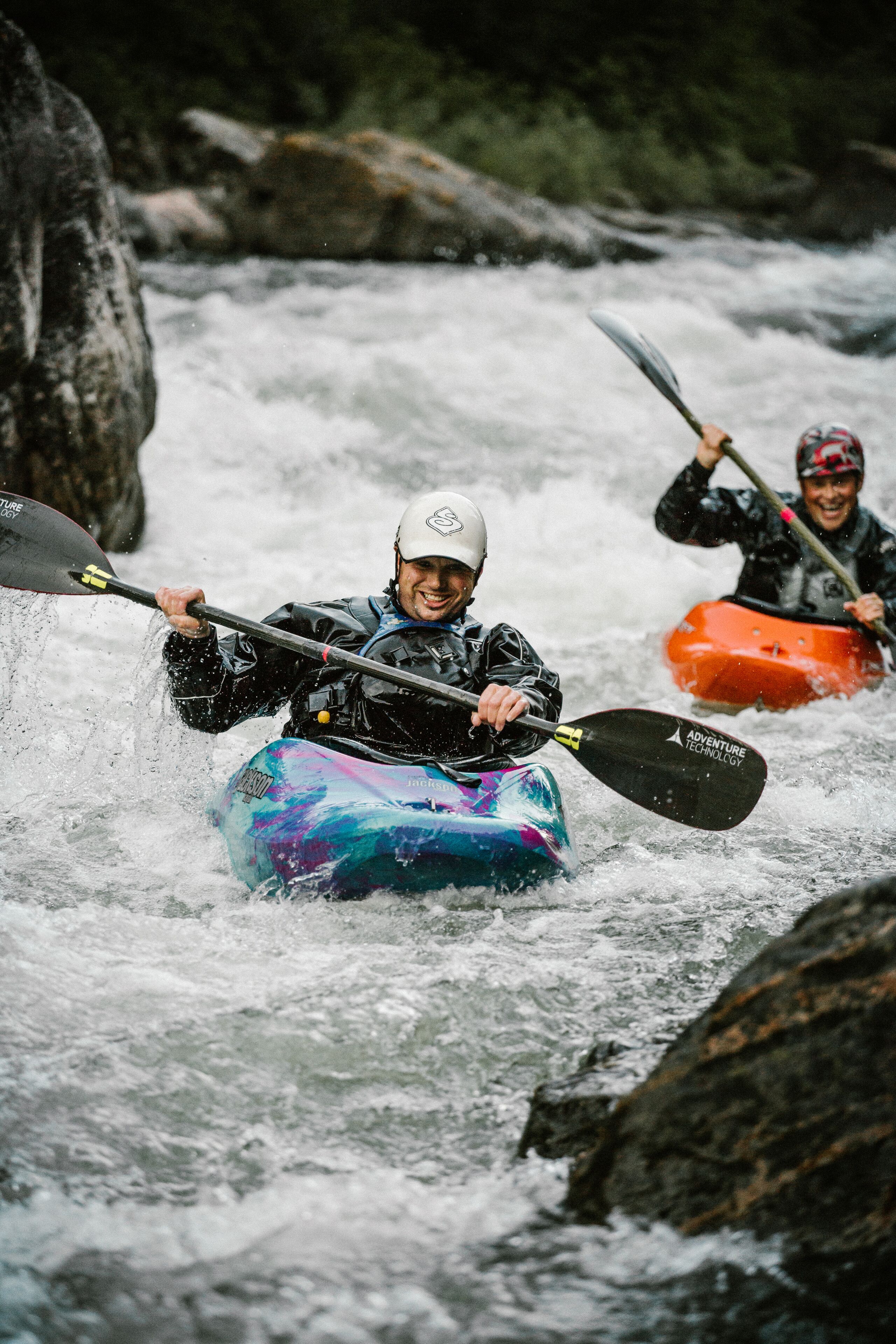 Dos personas haciendo kayak en un río.