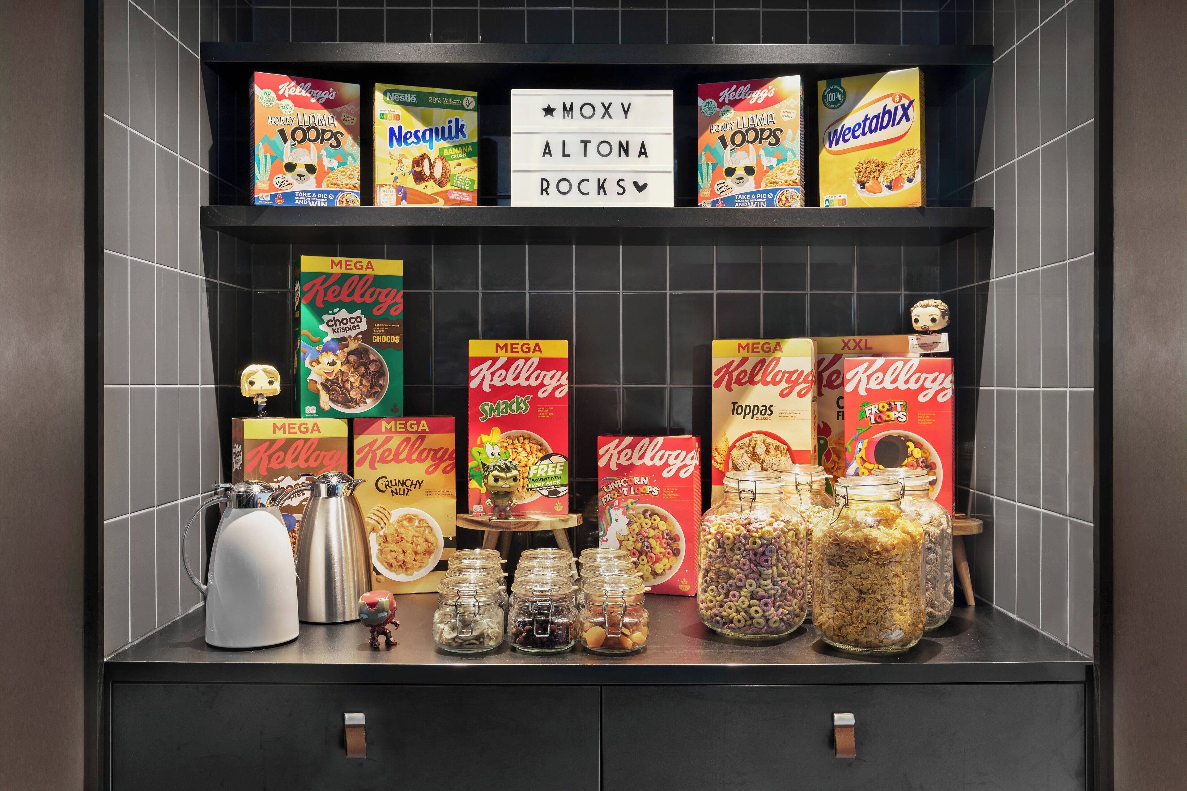 A shelf with various Kellogg's cereal boxes and jars of cereal.