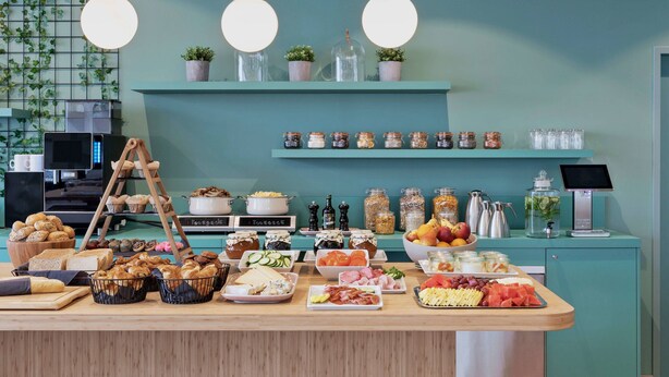 A breakfast buffet with various food items, jars of condiments, and a coffee machine. - Residence Inn by Marriott Hamburg Altona (Hamburg)