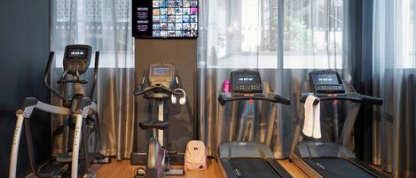 A gym with treadmills, an elliptical, and a stationary bike.