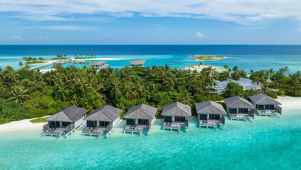 An aerial view of overwater bungalows with clear turquoise waters and a beach. - Le Meridien Maldives Resort & Spa (Thilamaafushi Island)