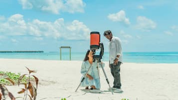 Di pantai, pasir putih, kerusi lepak pantai, payung