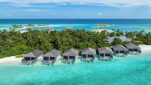 An overwater resort with multiple bungalow-style accommodations, clear turquoise waters, and a tropical backdrop. - Le Meridien Maldives Resort & Spa (Thilamaafushi Island)