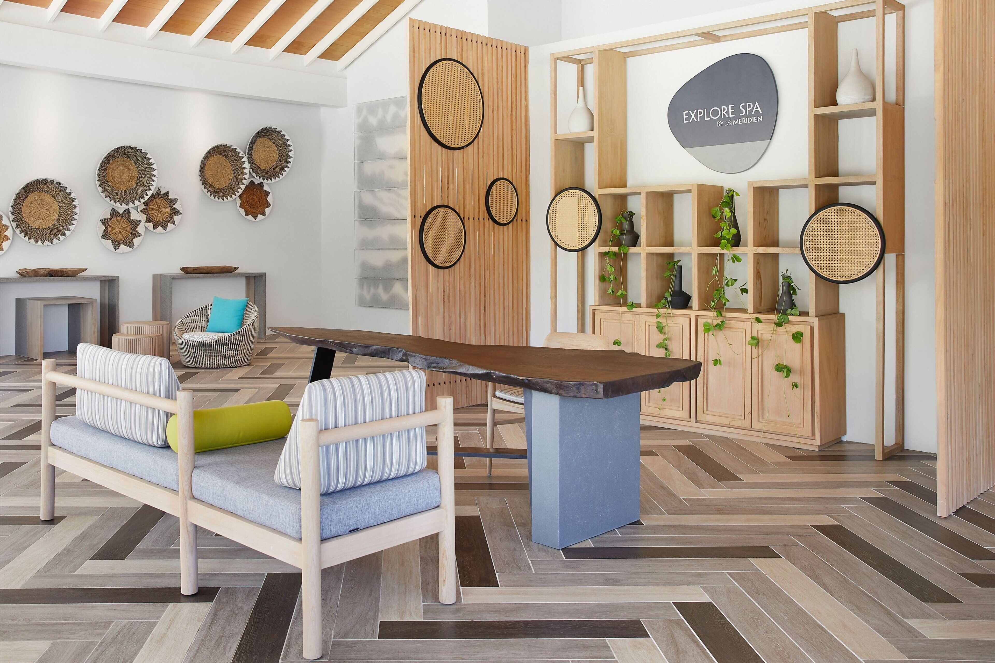 Un interior moderno con un sofá de madera, una mesa central y una estantería con plantas.