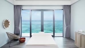 A room with a large sliding glass door leading to a balcony with a view of the ocean. - Le Meridien Maldives Resort & Spa (Thilamaafushi Island)