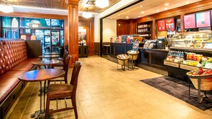 A restaurant with a booth seating area, tables, and a counter with a beverage display.