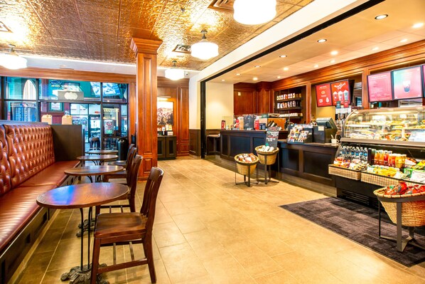 Un restaurante con zona de asientos tipo cabina, mesas y una barra con exhibición de bebidas.