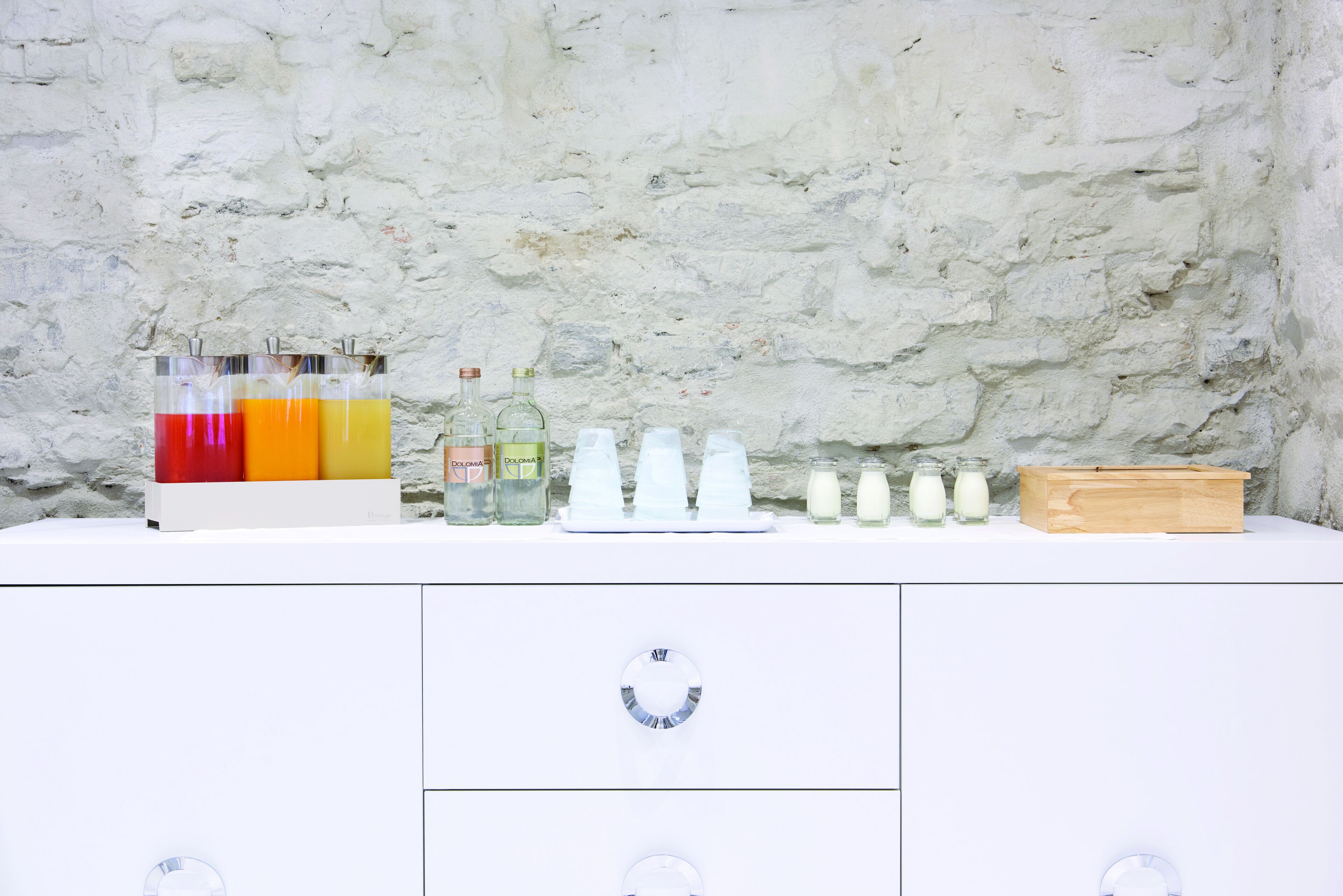 A white cabinet with drawers and a countertop displaying various bottles and containers.